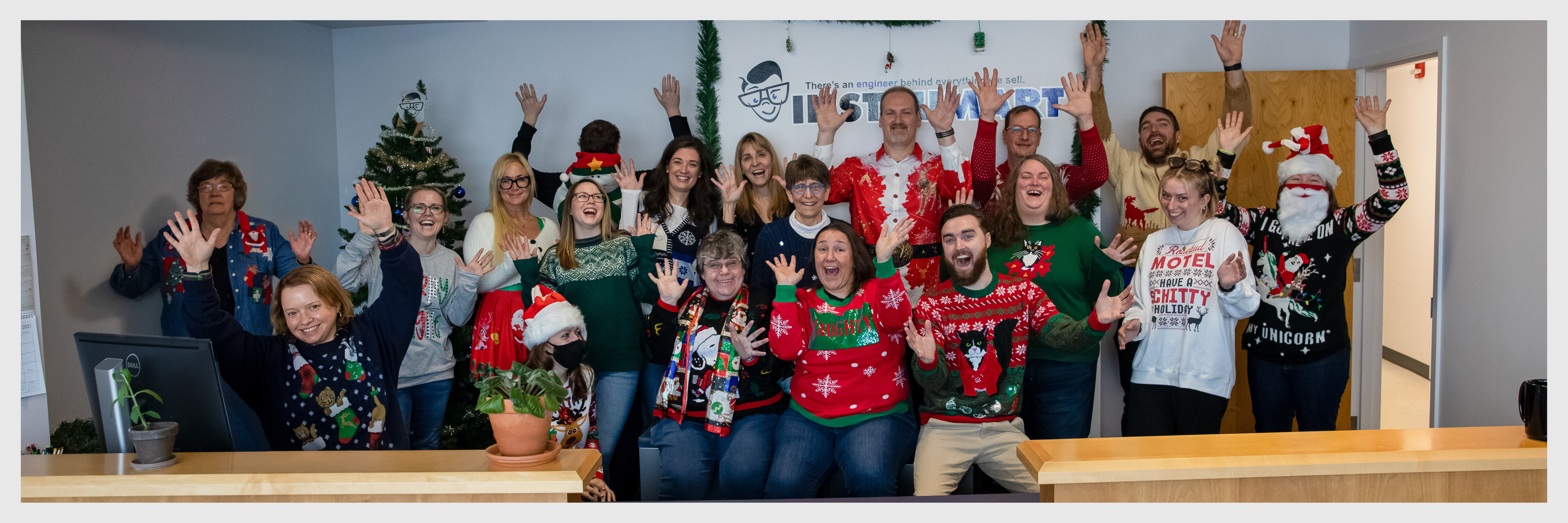 Photo of Instrumart employees doing a goofy pose in holiday sweaters.