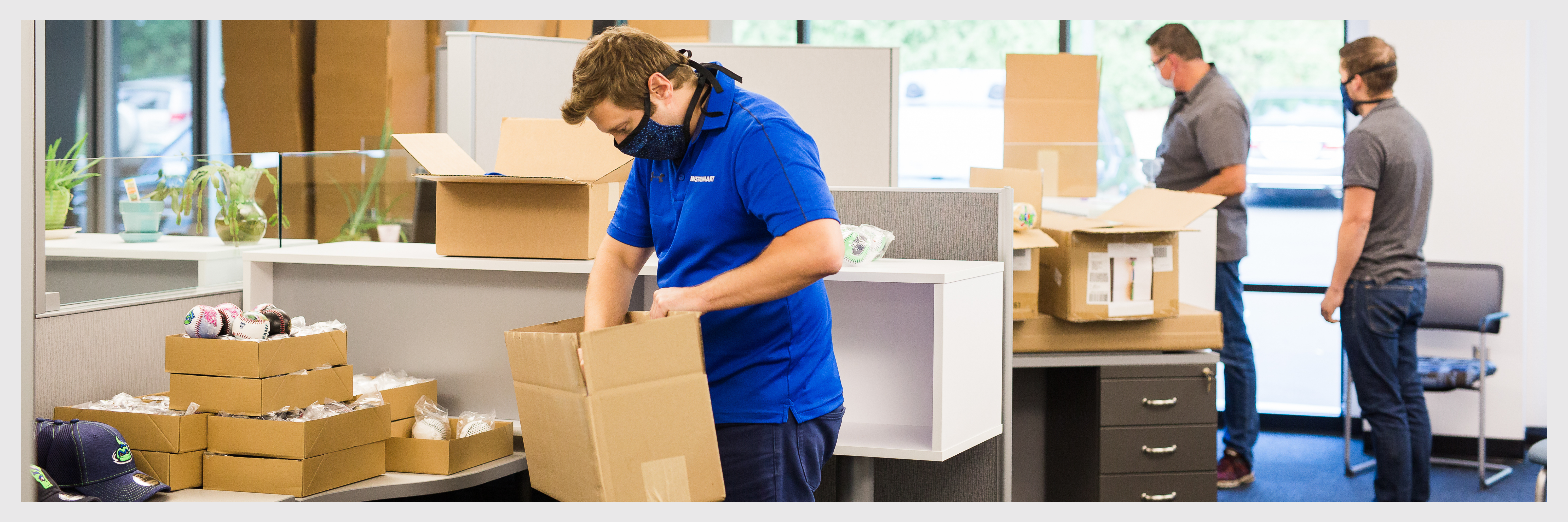 Image of Instrumart employees preparing gift boxes for the Make-A-Wish Foundation.