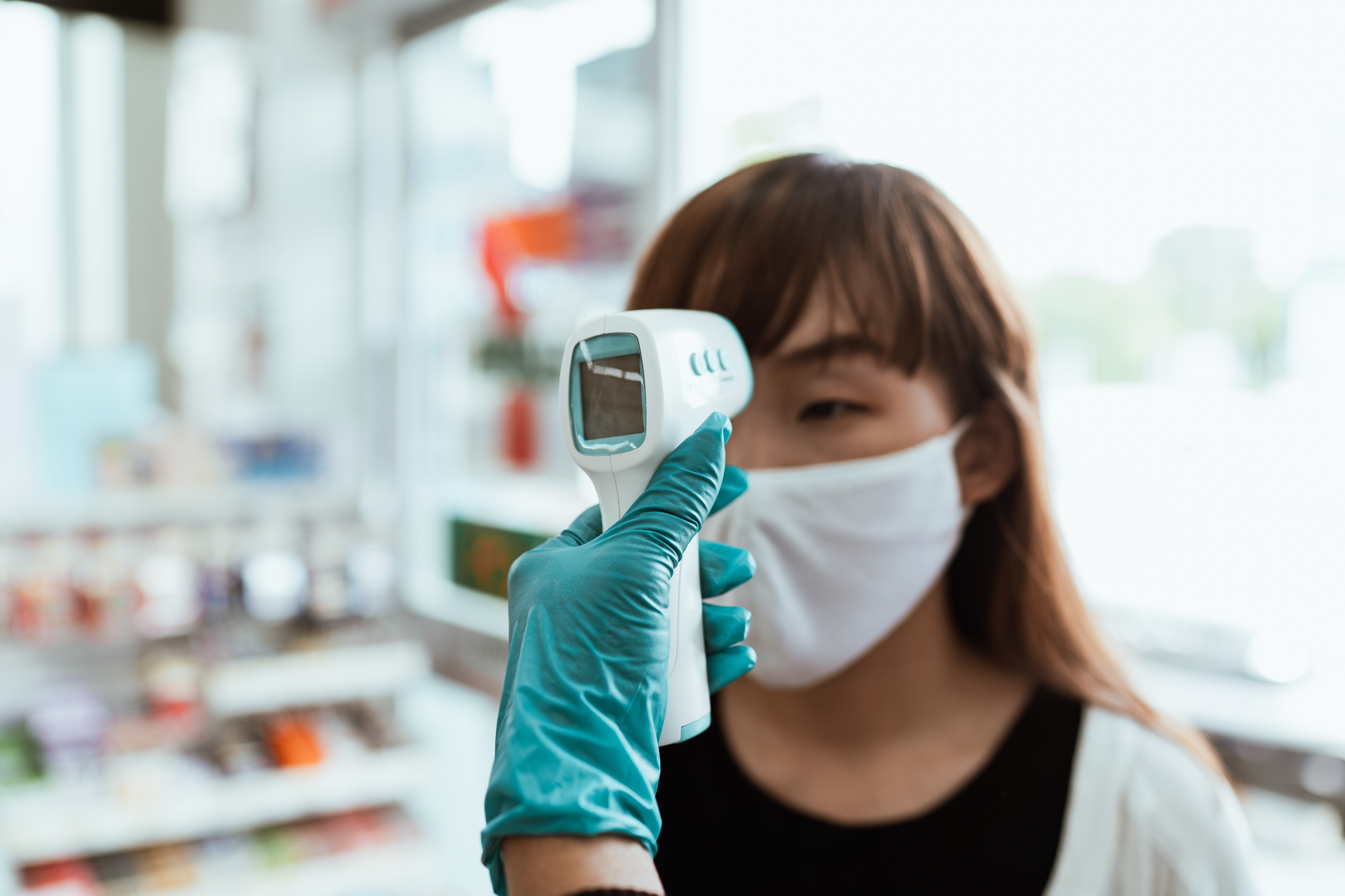 Non-contact infrared thermometer taking a woman's temperature.